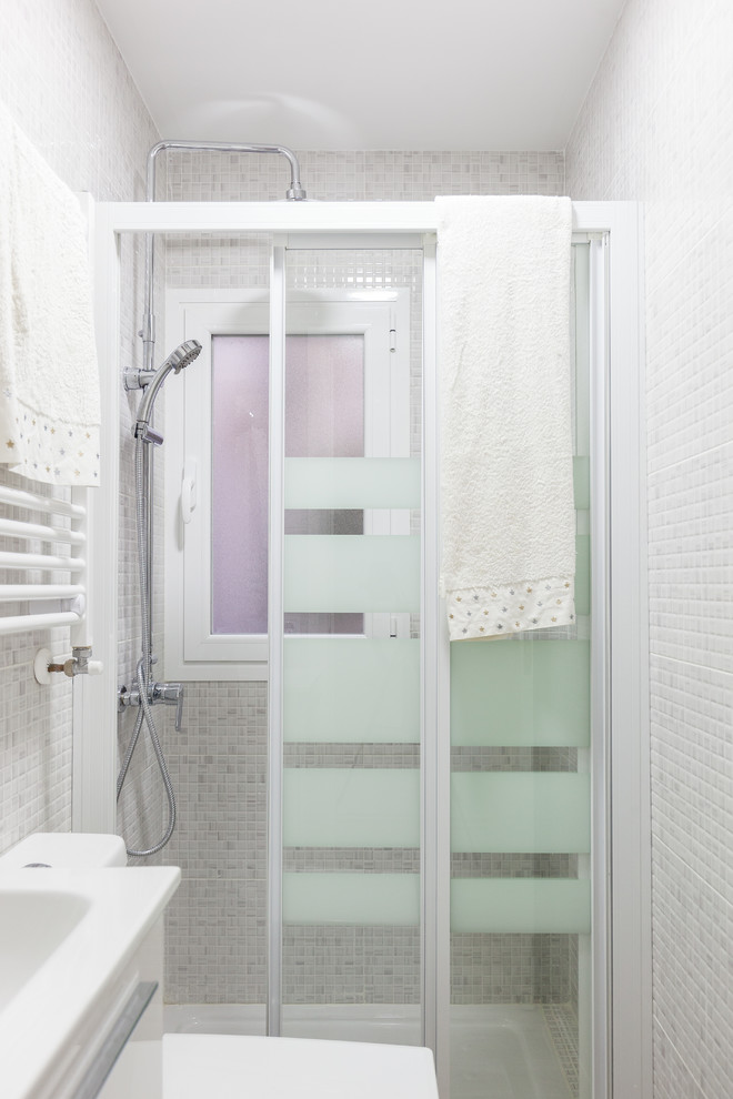 Foto de cuarto de baño principal actual pequeño con puertas de armario blancas, sanitario de una pieza, paredes grises, suelo de baldosas de cerámica, lavabo suspendido, suelo gris y ducha con puerta corredera