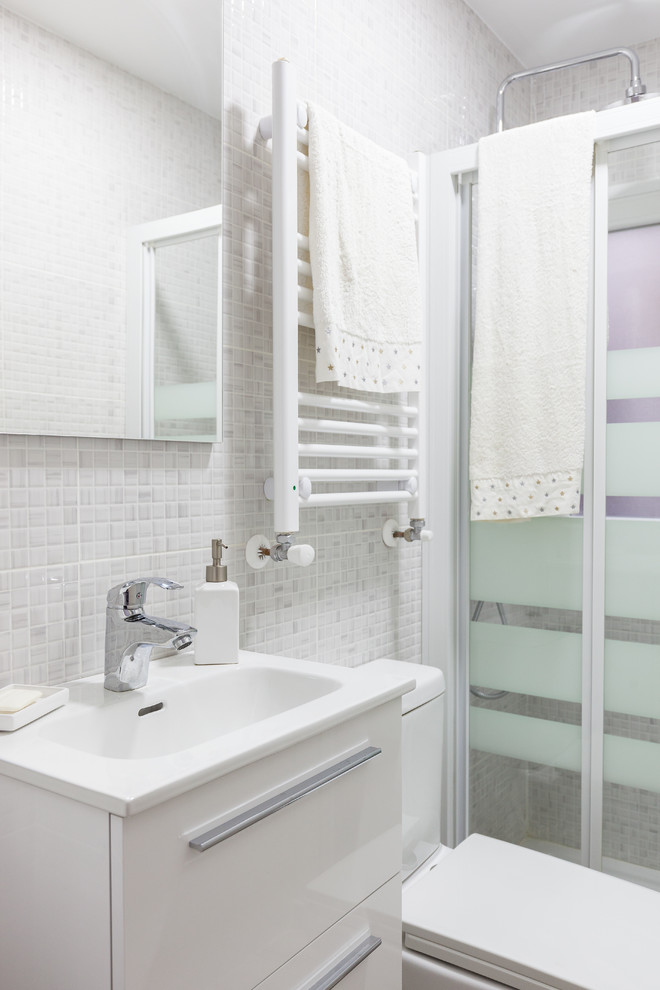 Imagen de cuarto de baño principal contemporáneo pequeño con puertas de armario blancas, sanitario de una pieza, paredes grises, suelo de baldosas de cerámica, lavabo suspendido, suelo gris y ducha con puerta corredera
