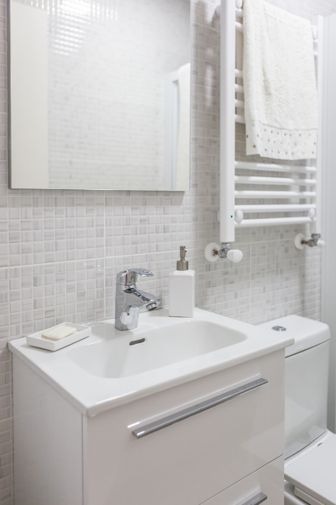 Idee per una piccola stanza da bagno padronale design con ante bianche, WC monopezzo, pareti grigie, pavimento con piastrelle in ceramica, lavabo sospeso, pavimento grigio e porta doccia scorrevole