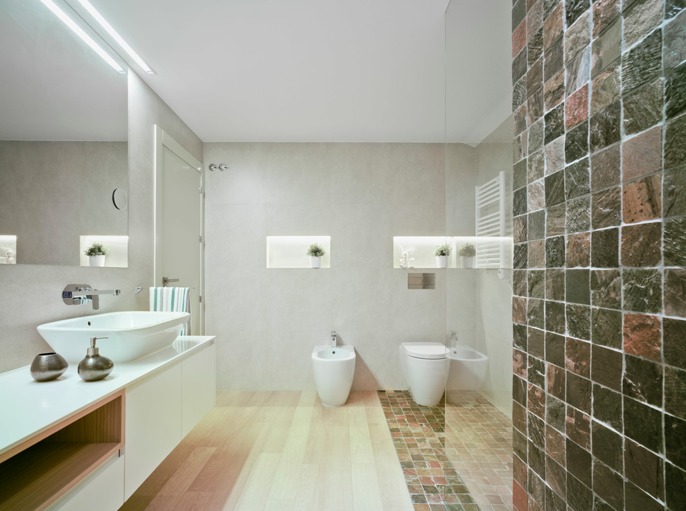 Diseño de cuarto de baño principal minimalista con ducha a ras de suelo, sanitario de pared, baldosas y/o azulejos de cerámica, suelo de pizarra y lavabo sobreencimera
