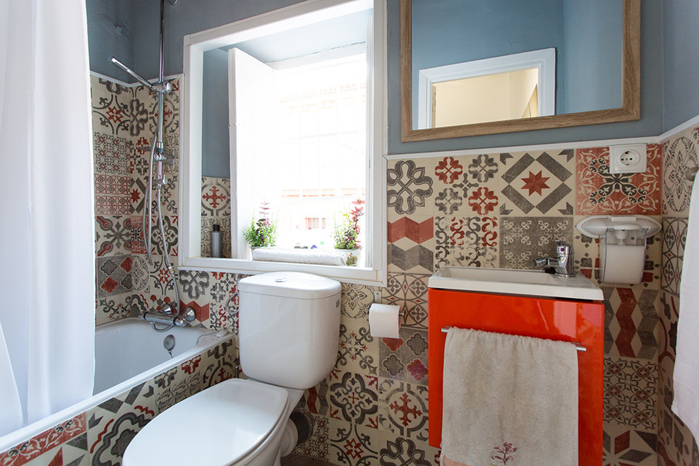 Esempio di una stanza da bagno padronale bohémian di medie dimensioni con ante lisce, ante rosse, vasca ad alcova, vasca/doccia, WC a due pezzi, pareti blu e lavabo integrato
