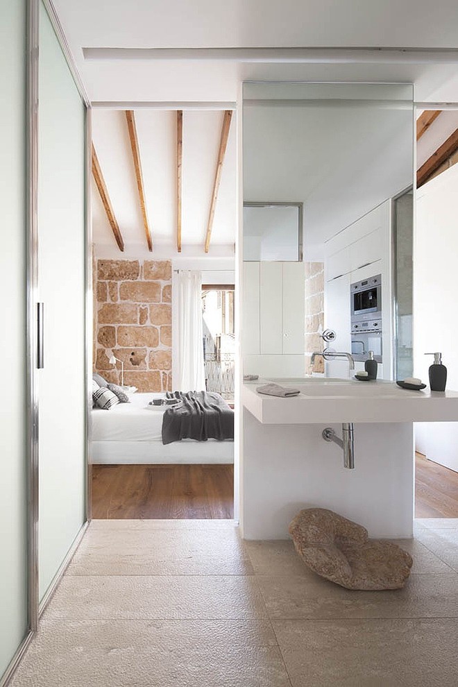 Aménagement d'une petite salle de bain montagne avec une douche à l'italienne, WC suspendus, un carrelage beige, un carrelage de pierre, un mur beige, un sol en bois brun et un lavabo suspendu.