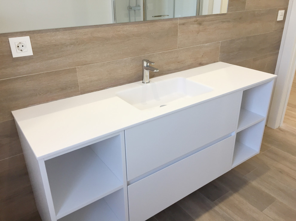 Inspiration for a large mediterranean ensuite bathroom in Bilbao with shaker cabinets, white cabinets, an alcove bath, a shower/bath combination, a wall mounted toilet, brown tiles, ceramic tiles, brown walls, light hardwood flooring, an integrated sink, engineered stone worktops, brown floors and a hinged door.