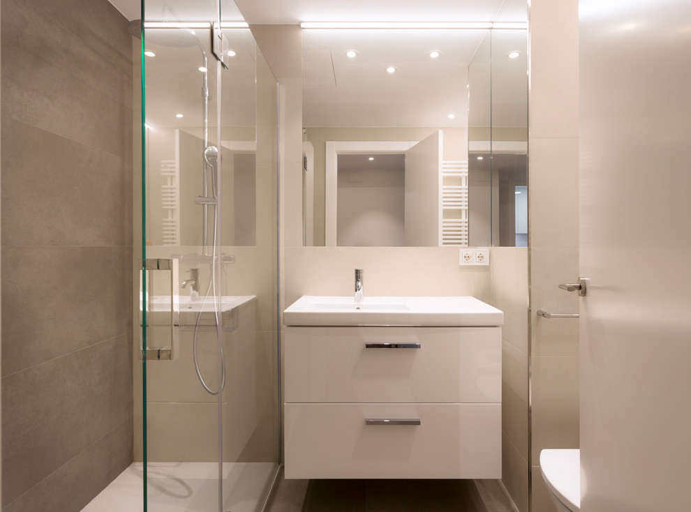 Inspiration för ett mellanstort funkis beige beige badrum med dusch, med vita skåp, en kantlös dusch, beige kakel, ett avlångt handfat och dusch med gångjärnsdörr