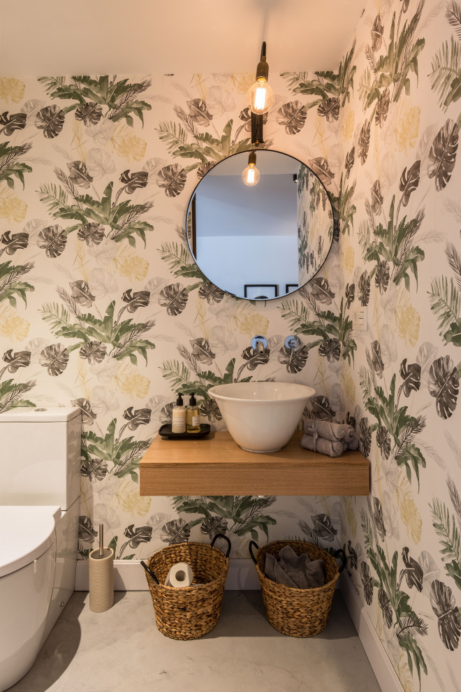 Immagine di una piccola stanza da bagno shabby-chic style con pavimento in cemento, lavabo a bacinella, top in legno e carta da parati