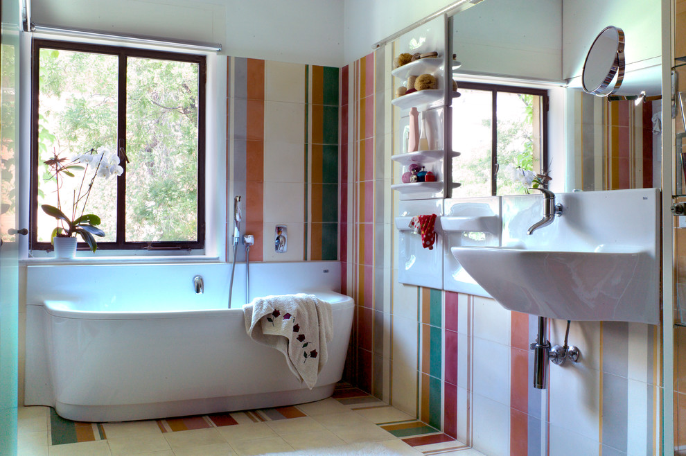Ispirazione per una stanza da bagno padronale minimal di medie dimensioni con vasca da incasso, vasca/doccia, piastrelle multicolore, piastrelle in ceramica, pareti multicolore, pavimento con piastrelle in ceramica e lavabo sospeso