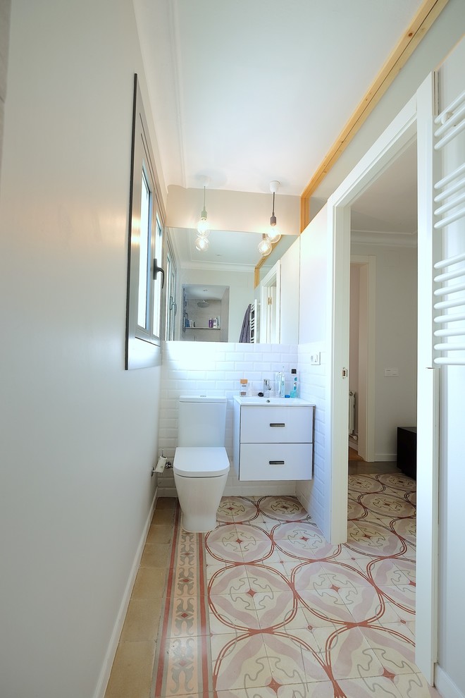 На фото: маленькая главная ванная комната в скандинавском стиле с фасадами островного типа, белыми фасадами, открытым душем, белой плиткой, керамической плиткой, белыми стенами, полом из терракотовой плитки и подвесной раковиной для на участке и в саду