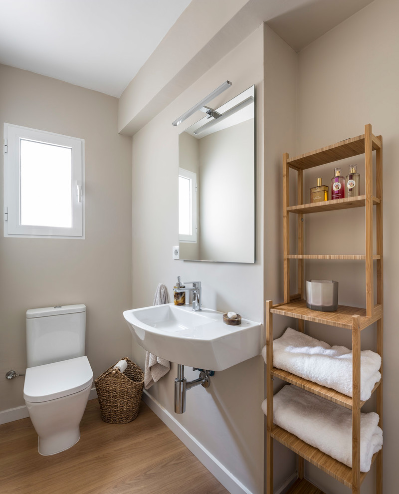 Foto di una stanza da bagno mediterranea con pareti beige, pavimento in legno massello medio e lavabo sospeso