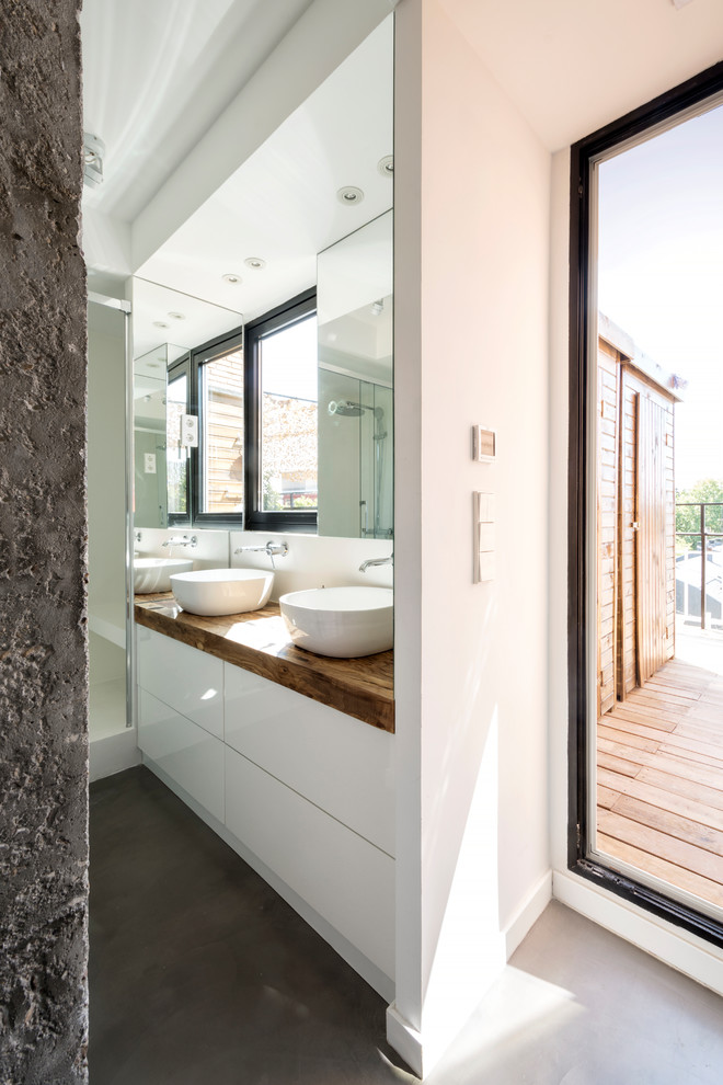 Diseño de cuarto de baño contemporáneo con armarios tipo mueble, puertas de armario blancas, suelo de cemento, aseo y ducha, suelo gris, ducha con puerta corredera y encimeras marrones