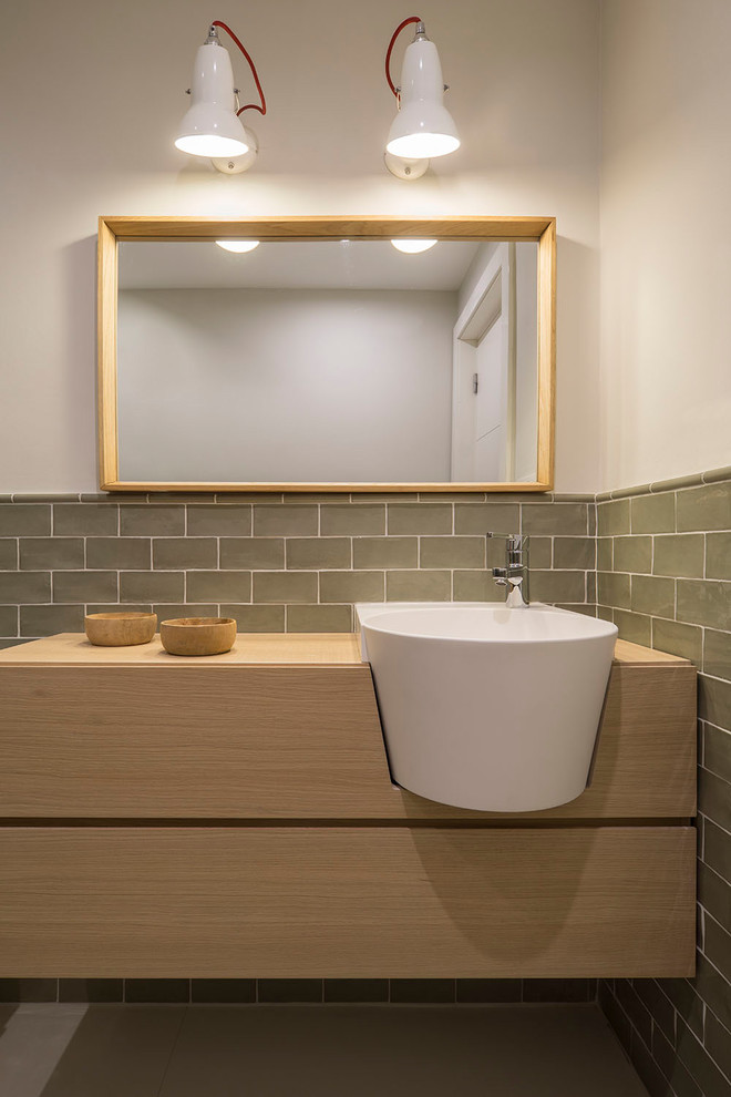 Réalisation d'une grande salle de bain principale design en bois clair avec un placard à porte shaker, un carrelage vert, des carreaux de céramique, un mur blanc, une vasque et un plan de toilette en bois.