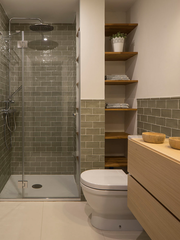 Idées déco pour une petite salle de bain principale contemporaine en bois clair avec un placard à porte shaker, un espace douche bain, WC à poser, un carrelage vert, des carreaux de céramique, un mur blanc, un sol en carrelage de céramique, une vasque, un plan de toilette en bois, un sol beige et une cabine de douche à porte coulissante.