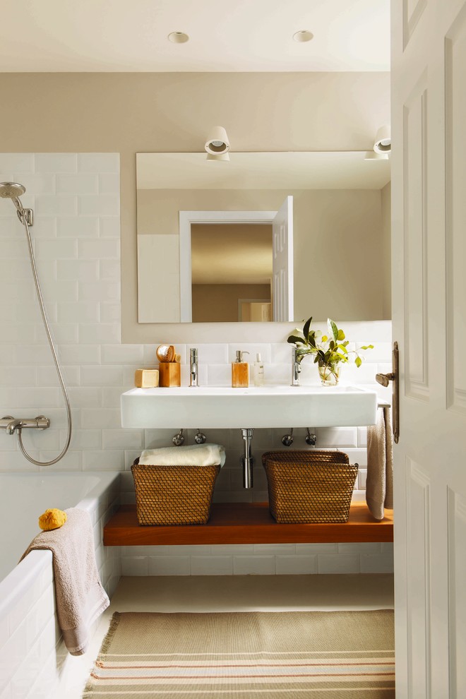 This is an example of a medium sized scandi ensuite bathroom in Other with open cabinets, medium wood cabinets, an alcove bath, a shower/bath combination, ceramic tiles, white walls and a wall-mounted sink.