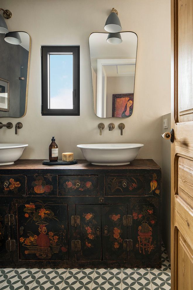 Пример оригинального дизайна: главная ванная комната среднего размера в средиземноморском стиле с темными деревянными фасадами, керамической плиткой, бежевыми стенами, полом из керамогранита, столешницей из дерева, разноцветным полом, настольной раковиной, коричневой столешницей и плоскими фасадами
