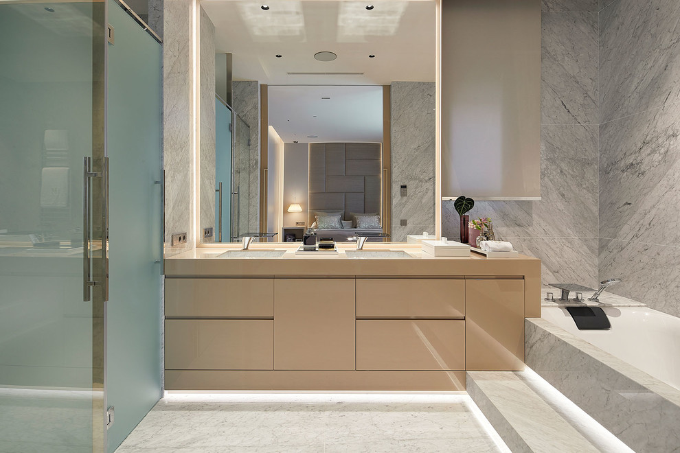 Réalisation d'une grande salle de bain principale design avec des portes de placard blanches, du carrelage en marbre, un mur blanc, un plan de toilette en marbre et un plan de toilette blanc.