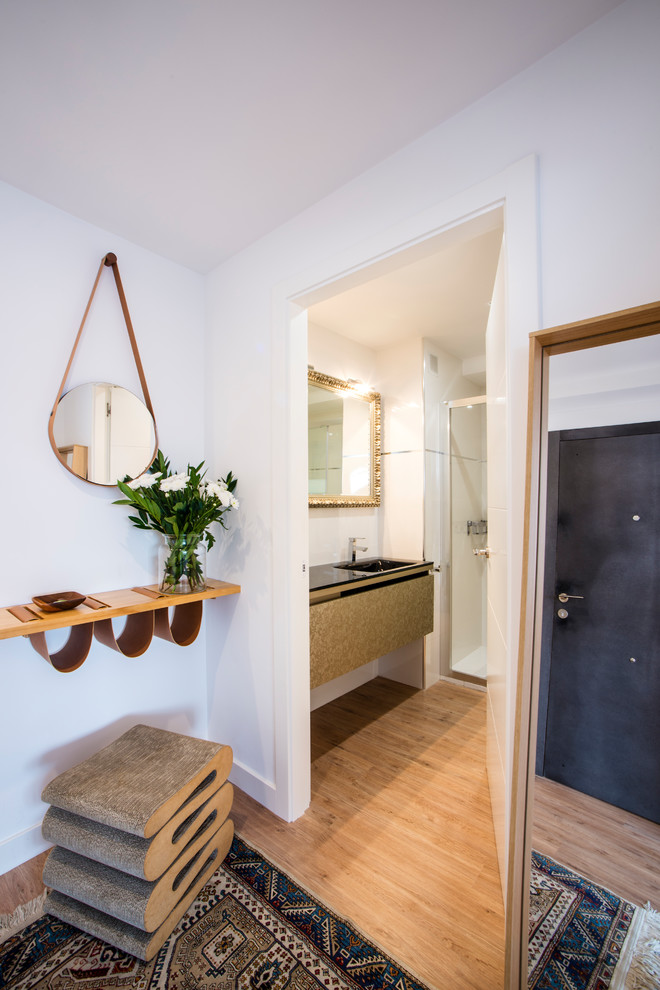 Esempio di una stanza da bagno design con doccia a filo pavimento, piastrelle bianche, pavimento in legno massello medio, lavabo integrato e top nero