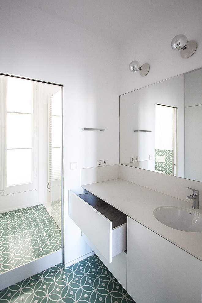 Inspiration for a mid-sized contemporary 3/4 cement tile floor and multicolored floor walk-in shower remodel in Barcelona with open cabinets, white cabinets, a wall-mount toilet, white walls, an undermount sink, tile countertops and white countertops