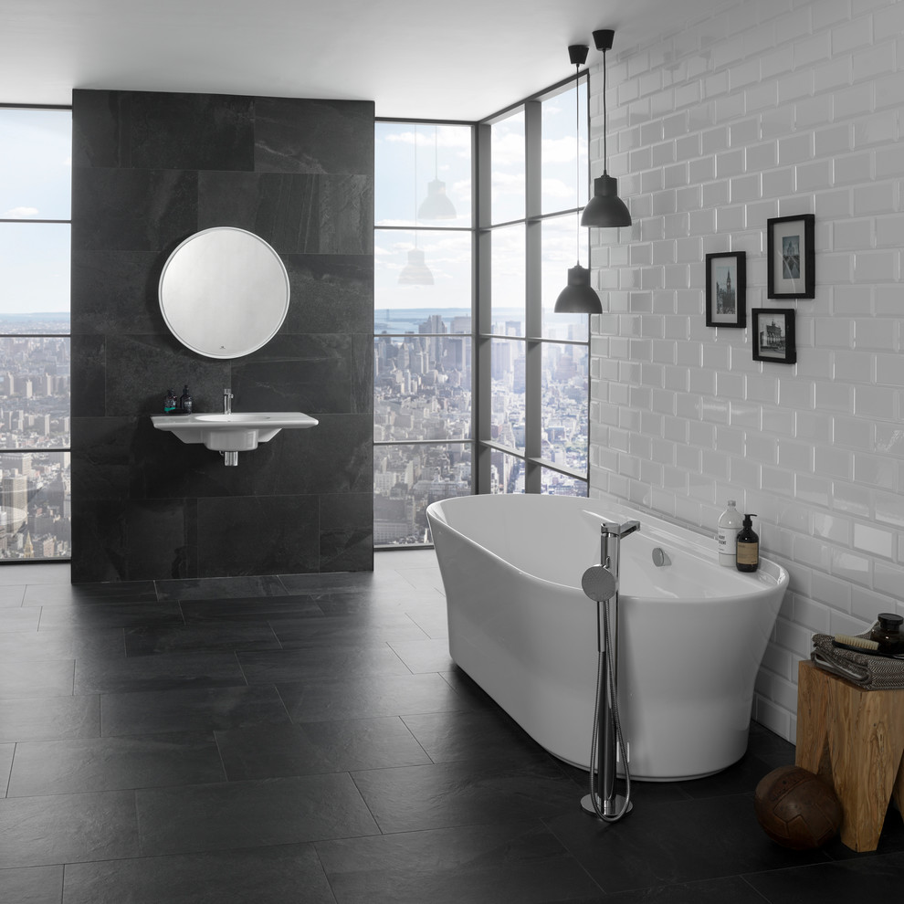 На фото: большая главная ванная комната в современном стиле с отдельно стоящей ванной, серой плиткой, керамической плиткой, белыми стенами, подвесной раковиной, серым полом и душем над ванной