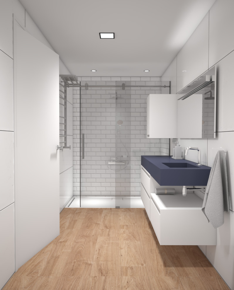 Idéer för ett litet modernt blå badrum med dusch, med släta luckor, blå skåp, en dusch i en alkov, vit kakel, vita väggar, ett integrerad handfat, bänkskiva i akrylsten, brunt golv och dusch med skjutdörr
