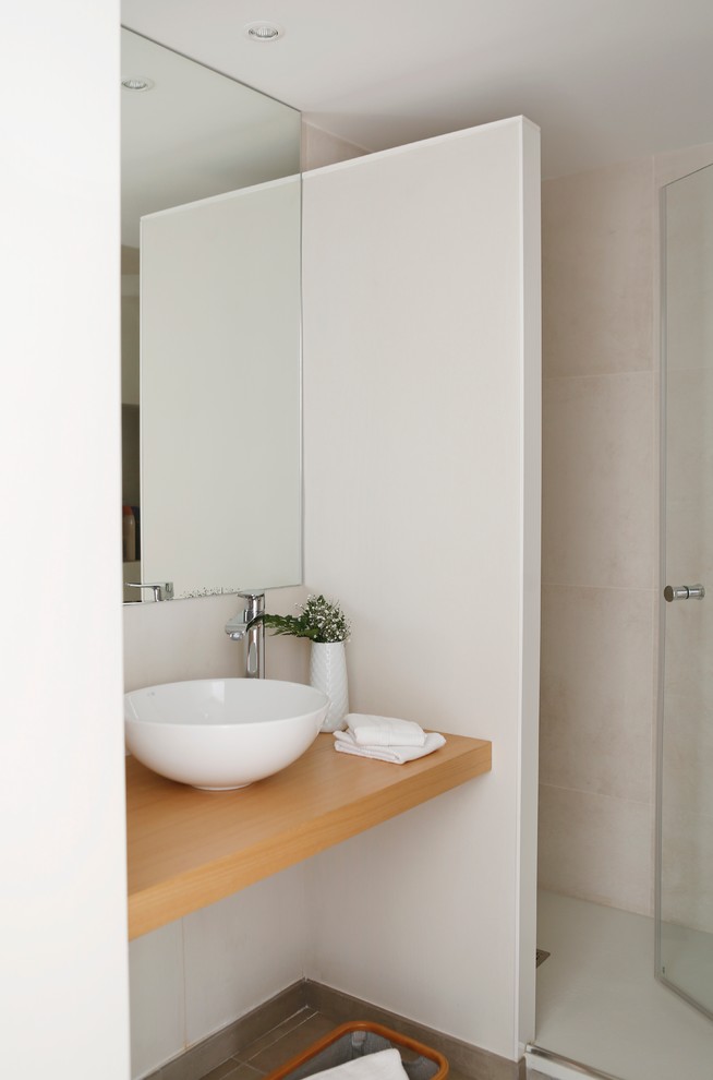 Modelo de cuarto de baño contemporáneo pequeño con ducha empotrada, paredes blancas, aseo y ducha, lavabo sobreencimera y encimera de madera