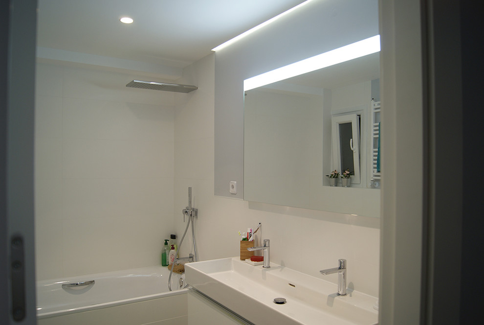 Источник вдохновения для домашнего уюта: главная ванная комната среднего размера с ванной в нише, раздельным унитазом, белой плиткой, керамогранитной плиткой, серыми стенами, полом из керамогранита, подвесной раковиной, серым полом и зеркалом с подсветкой