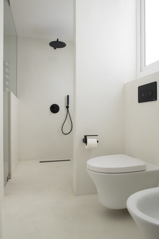 Medium sized contemporary ensuite bathroom in Barcelona with open cabinets, white cabinets, a built-in shower, a wall mounted toilet, white tiles, white walls, concrete flooring, a vessel sink, engineered stone worktops, white floors, a hinged door and white worktops.