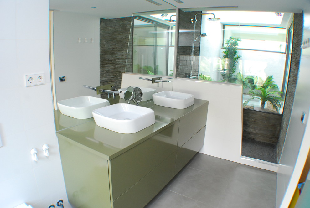 Exempel på ett modernt badrum, med släta luckor, gröna skåp, våtrum, en vägghängd toalettstol, grå kakel, keramikplattor, vita väggar, klinkergolv i keramik och träbänkskiva