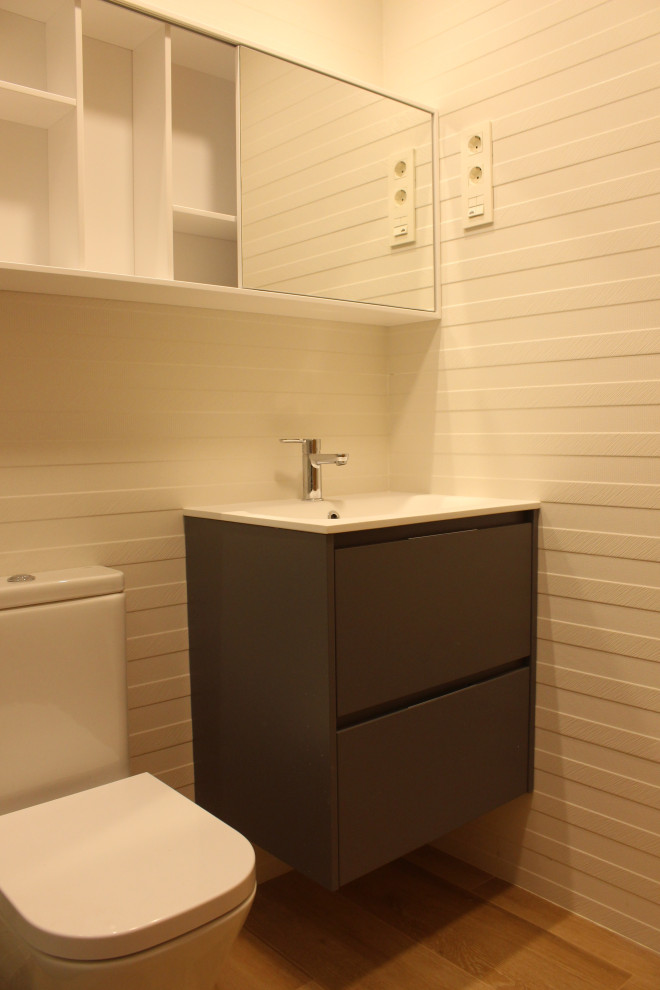 Foto på ett mellanstort funkis vit badrum med dusch, med grå skåp, våtrum, vit kakel, keramikplattor, vita väggar, klinkergolv i porslin, ett integrerad handfat, bänkskiva i akrylsten och dusch med skjutdörr
