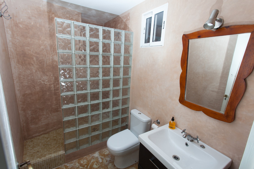 Modelo de cuarto de baño rústico de tamaño medio con armarios con paneles lisos, puertas de armario negras, ducha empotrada, sanitario de dos piezas, aseo y ducha y lavabo de seno grande
