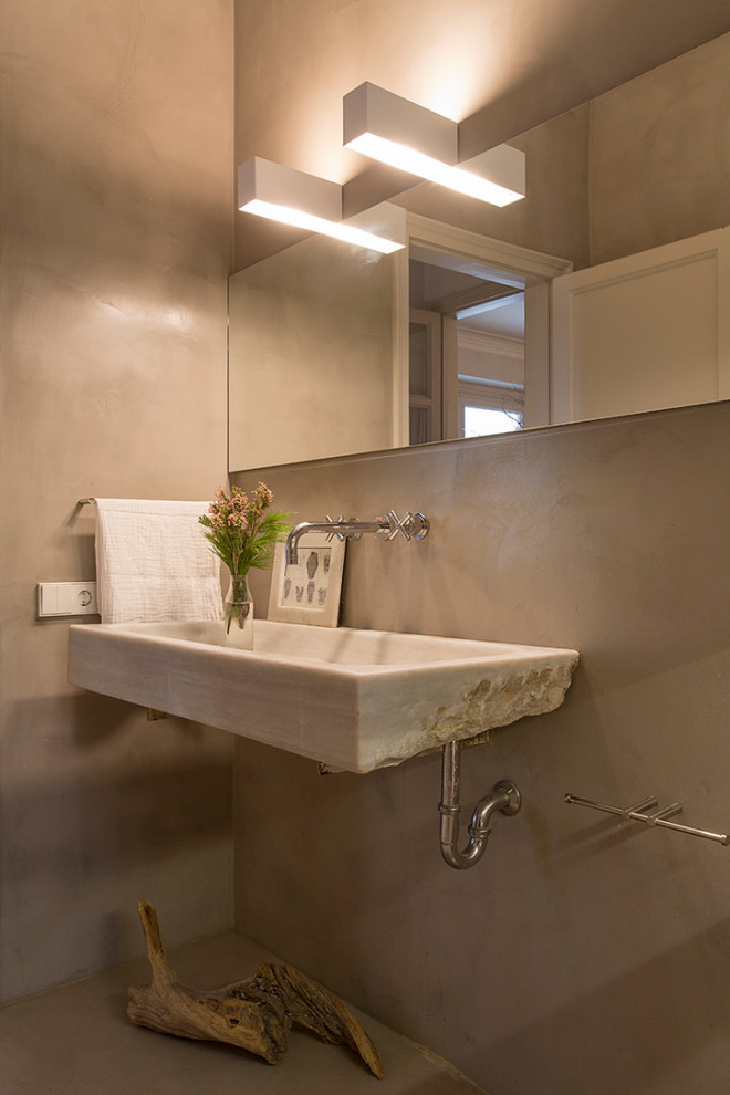 Ejemplo de cuarto de baño contemporáneo de tamaño medio con paredes grises, suelo de cemento, lavabo suspendido, suelo gris y microcemento