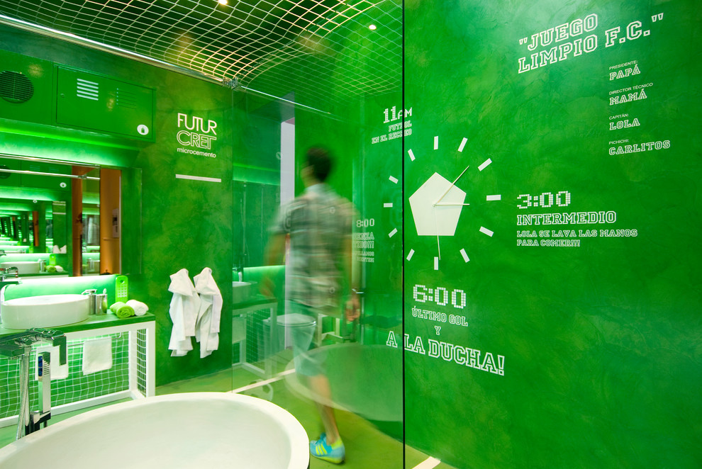 Eklektisk inredning av ett stort badrum för barn, med ett fristående badkar, en vägghängd toalettstol, gröna väggar, ett fristående handfat, grönt golv, dusch med skjutdörr och betonggolv