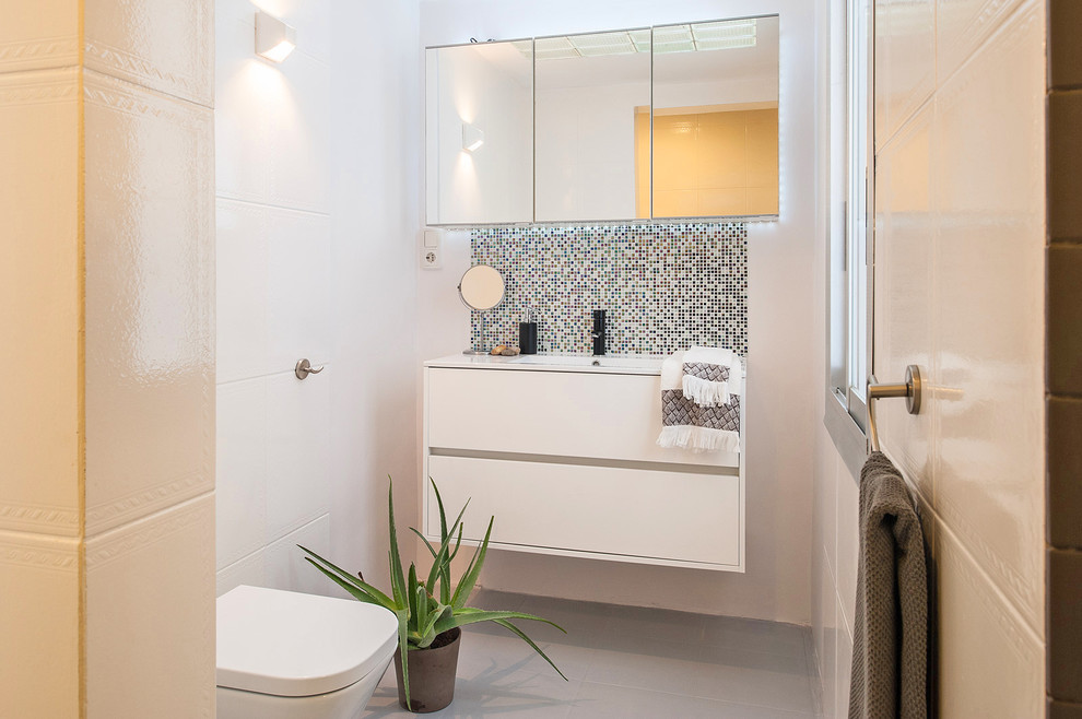 Modernes Badezimmer mit flächenbündigen Schrankfronten, Wandtoilette, weißer Wandfarbe, Keramikboden und Wandwaschbecken in Barcelona