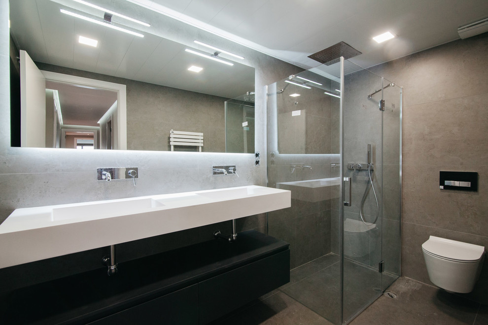 Ejemplo de cuarto de baño minimalista de tamaño medio con ducha esquinera, sanitario de pared, aseo y ducha, lavabo integrado y ducha con puerta con bisagras