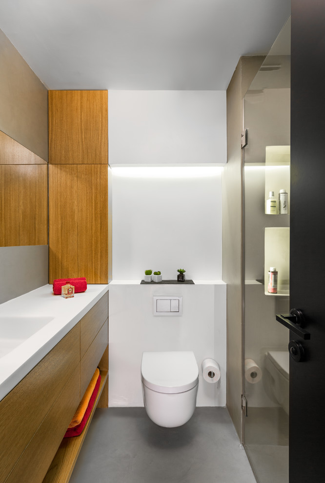Example of a mid-sized trendy master white tile and cement tile concrete floor and gray floor walk-in shower design in Madrid with flat-panel cabinets, brown cabinets, a wall-mount toilet, white walls, quartz countertops, a hinged shower door and white countertops