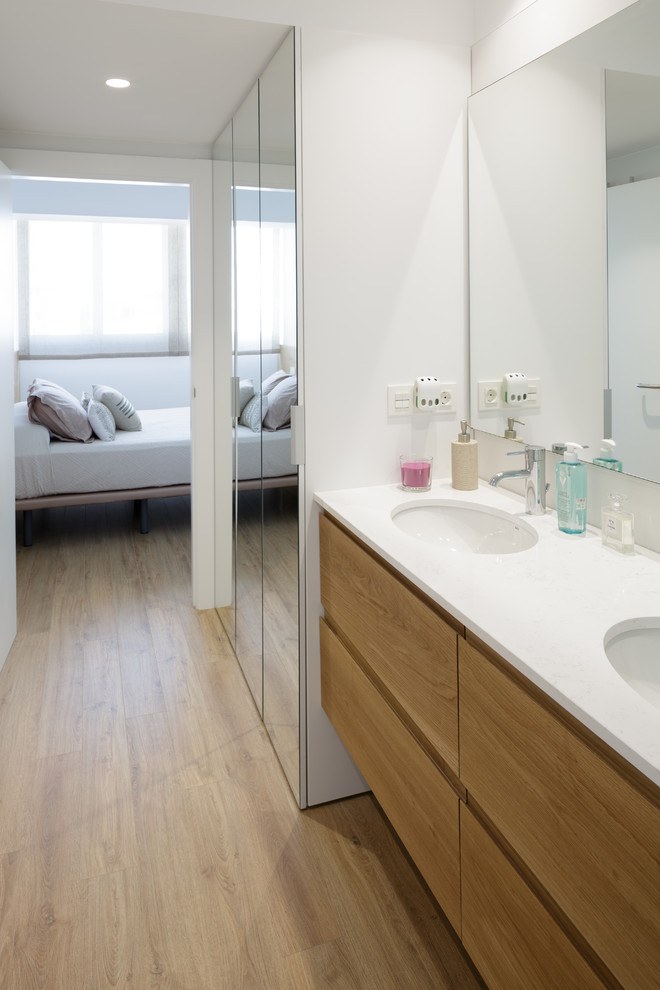 Minimalist master ceramic tile medium tone wood floor wet room photo in Alicante-Costa Blanca with flat-panel cabinets, medium tone wood cabinets, a wall-mount toilet, white walls, an undermount sink, quartz countertops, a hinged shower door and white countertops