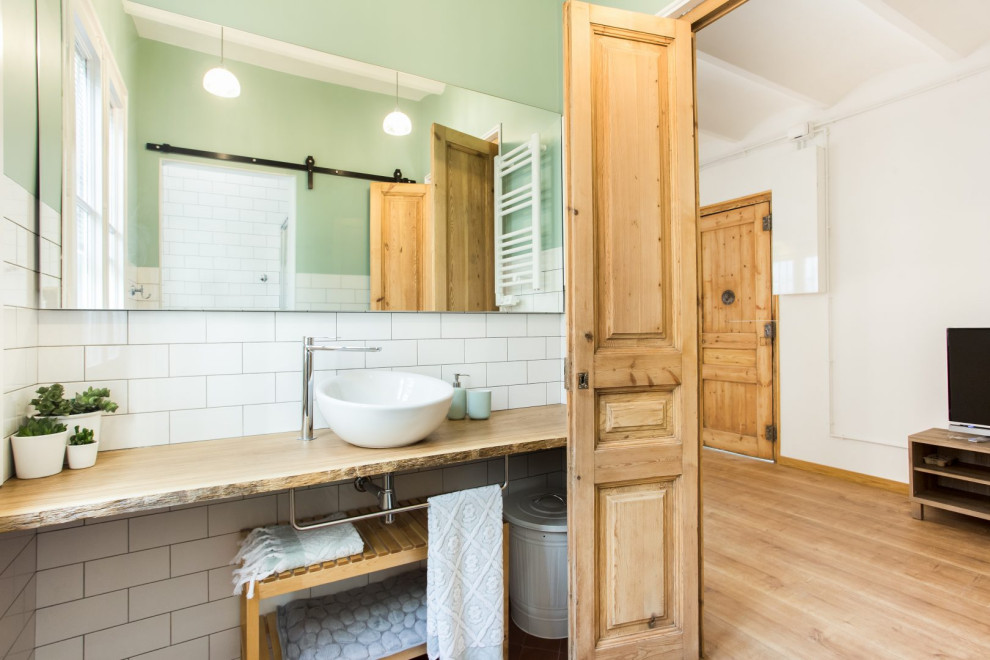 This is an example of a medium sized contemporary ensuite wet room bathroom in Barcelona with raised-panel cabinets, medium wood cabinets, white tiles, green walls, medium hardwood flooring, wooden worktops, an enclosed toilet, a single sink, a built in vanity unit and a vaulted ceiling.