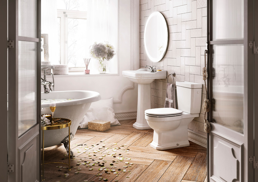 Aménagement d'une salle de bain campagne avec des portes de placard blanches, une baignoire sur pieds, WC séparés, un carrelage beige, un mur blanc, un sol en bois brun, un lavabo de ferme, un sol beige et un plan de toilette blanc.