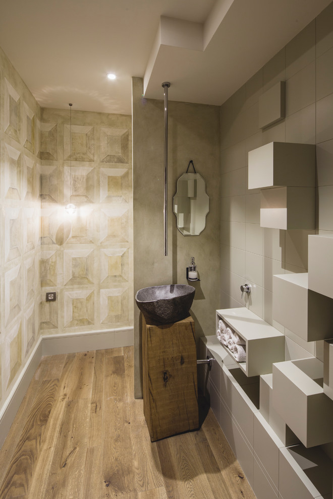 Mittelgroßes Modernes Duschbad mit Aufsatzwaschbecken, offenen Schränken, grauen Schränken, grauen Fliesen, braunem Holzboden und grauer Wandfarbe in Barcelona