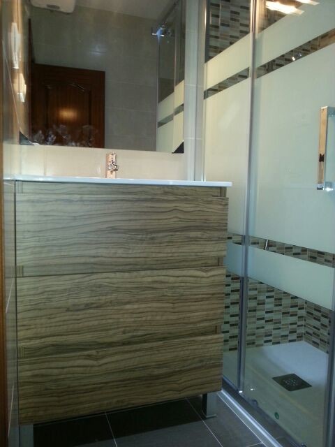 Modelo de cuarto de baño tradicional renovado de tamaño medio con armarios con paneles lisos, puertas de armario de madera oscura, ducha empotrada, aseo y ducha y lavabo integrado