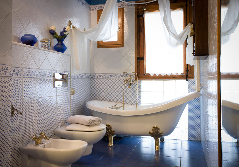 Idee per una piccola stanza da bagno con doccia mediterranea con vasca con piedi a zampa di leone, bidè, piastrelle blu, piastrelle bianche, piastrelle in ceramica, pareti blu, pavimento con piastrelle in ceramica, vasca/doccia e pavimento blu