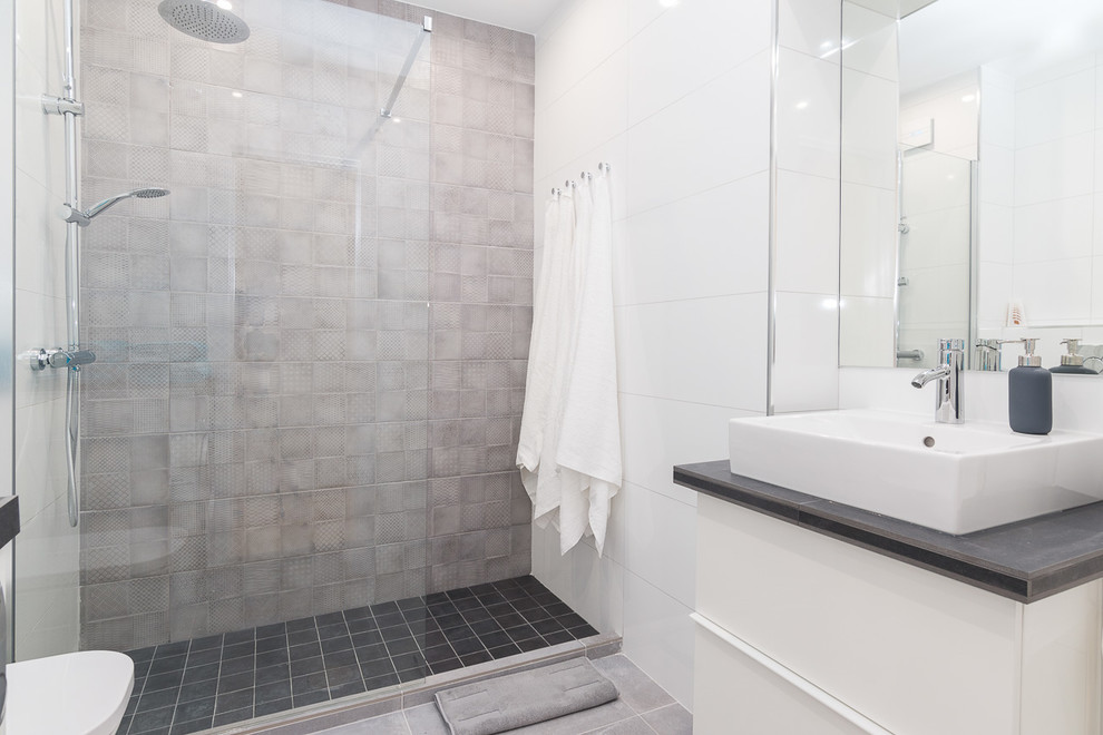 This is an example of a large mediterranean shower room bathroom in Other with freestanding cabinets, white cabinets, a walk-in shower, an urinal, grey tiles, ceramic tiles, grey walls, porcelain flooring, a vessel sink, engineered stone worktops and grey floors.
