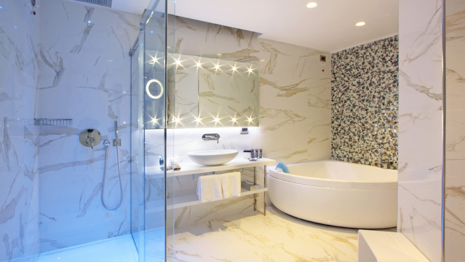 Modelo de cuarto de baño principal actual de tamaño medio con armarios abiertos, bañera esquinera, combinación de ducha y bañera, paredes multicolor y lavabo sobreencimera