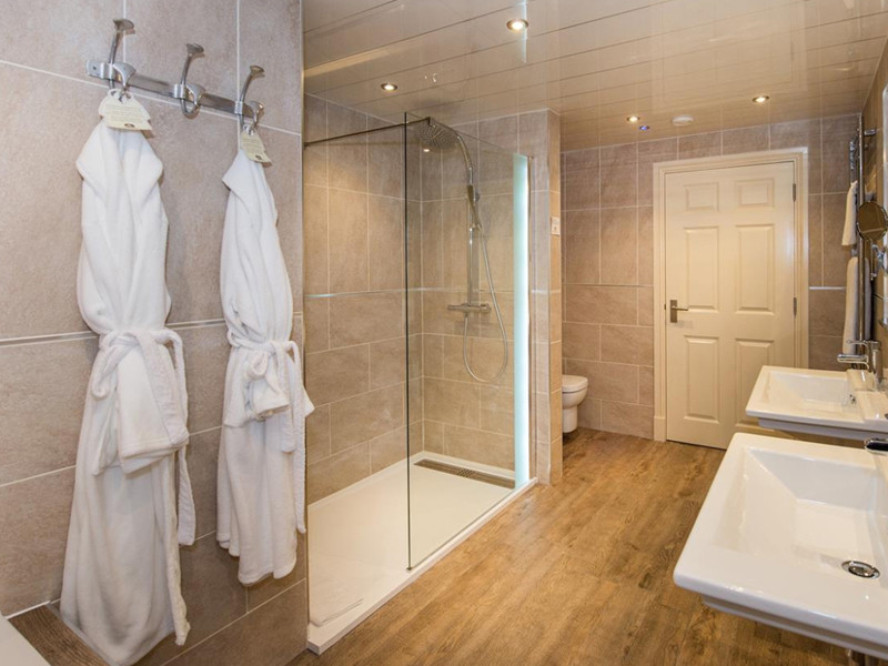 Ispirazione per una stanza da bagno tradizionale con doccia a filo pavimento, pareti beige, pavimento in legno massello medio e doccia aperta