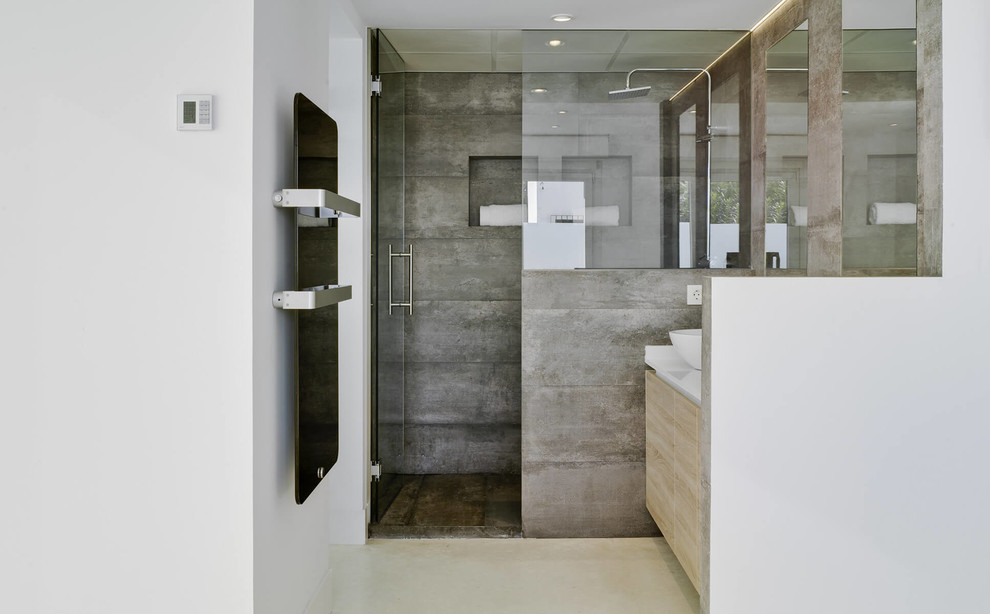 Foto på ett mellanstort medelhavsstil badrum med dusch, med släta luckor, skåp i ljust trä, en dusch i en alkov och ett fristående handfat