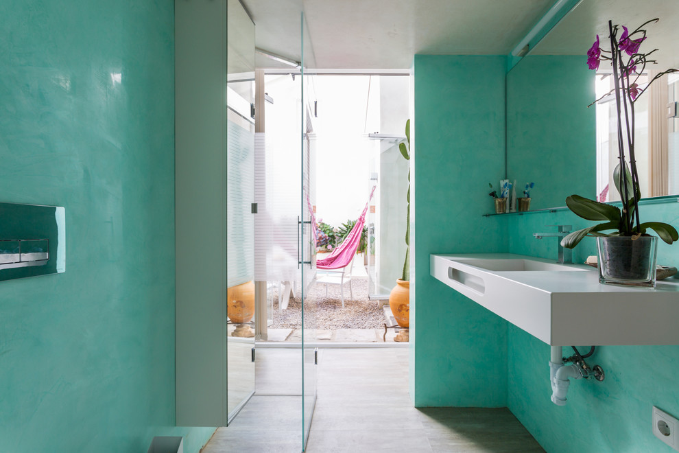 セビリアにある地中海スタイルのおしゃれなバスルーム (浴槽なし) (青い壁、白い洗面カウンター、バリアフリー、一体型シンク、開き戸のシャワー) の写真