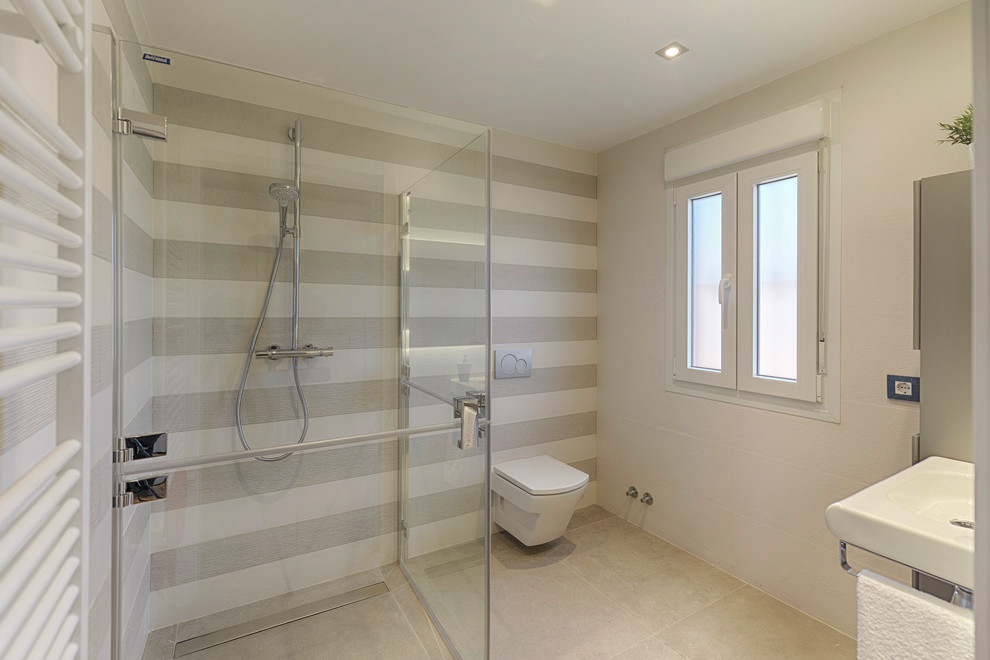 Идея дизайна: ванная комната среднего размера в стиле неоклассика (современная классика) с душем без бортиков, серыми стенами, полом из керамогранита, подвесной раковиной, серым полом и душем с распашными дверями