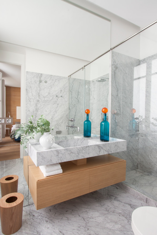 Inspiration pour une salle de bain nordique en bois clair de taille moyenne avec un lavabo suspendu, un placard à porte plane, un plan de toilette en marbre, un carrelage gris, des dalles de pierre, un mur gris et un sol en marbre.