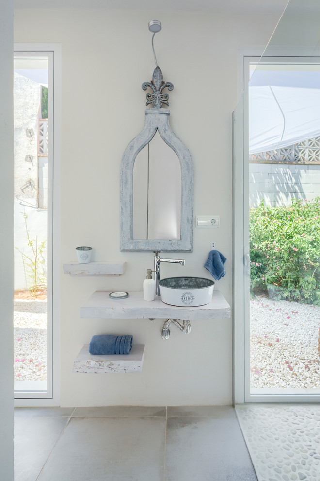 Foto de cuarto de baño principal mediterráneo de tamaño medio con ducha a ras de suelo, paredes blancas, lavabo sobreencimera, encimera de madera, suelo gris, ducha abierta y encimeras blancas