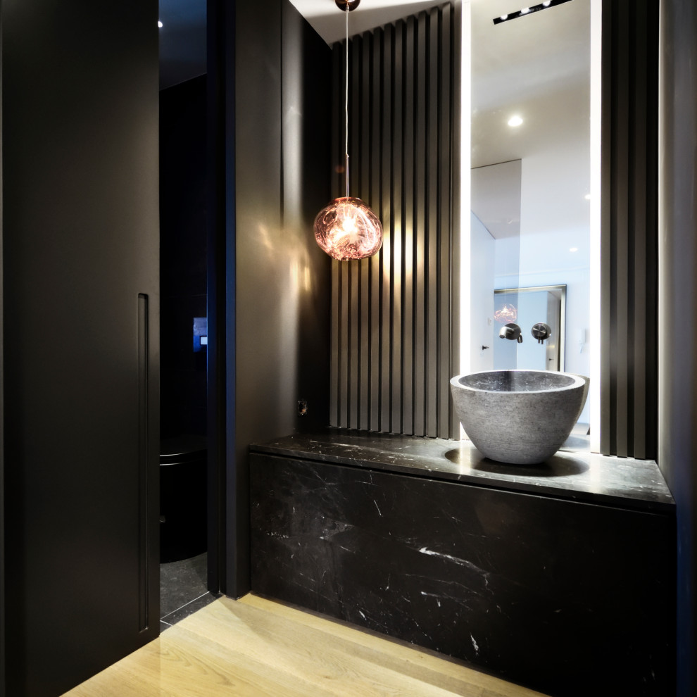 Foto di una stanza da bagno design di medie dimensioni con ante lisce, ante nere, piastrelle nere, pareti bianche, lavabo a bacinella, pavimento beige e top nero