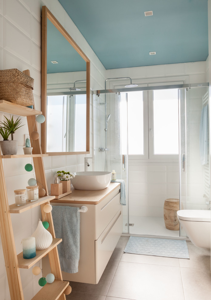 Inspiration för minimalistiska beige badrum med dusch, med släta luckor, beige skåp, en dusch i en alkov, vit kakel, vita väggar, ett fristående handfat, träbänkskiva, beiget golv och dusch med skjutdörr