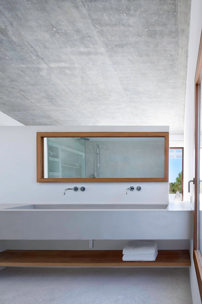 Modelo de cuarto de baño principal contemporáneo grande con lavabo de seno grande, armarios abiertos, puertas de armario de madera oscura, paredes grises, suelo de cemento, encimera de cemento y microcemento